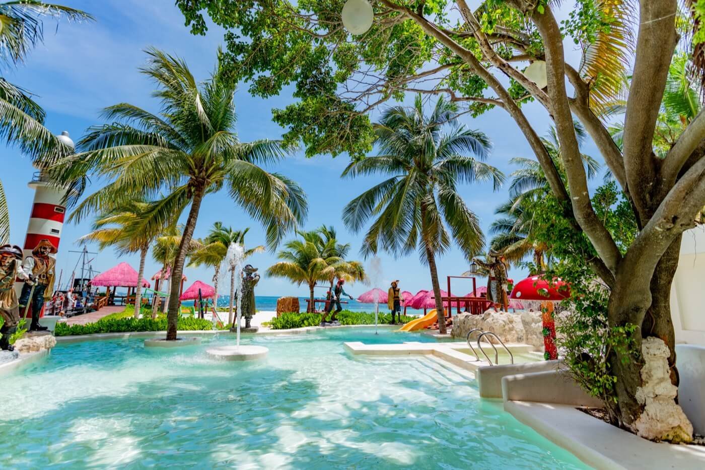Beds under palm trees on the beach at Hotel Grand Oasis Palm